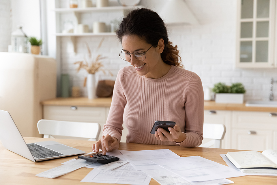 Young latina female work with financial papers count on calculator